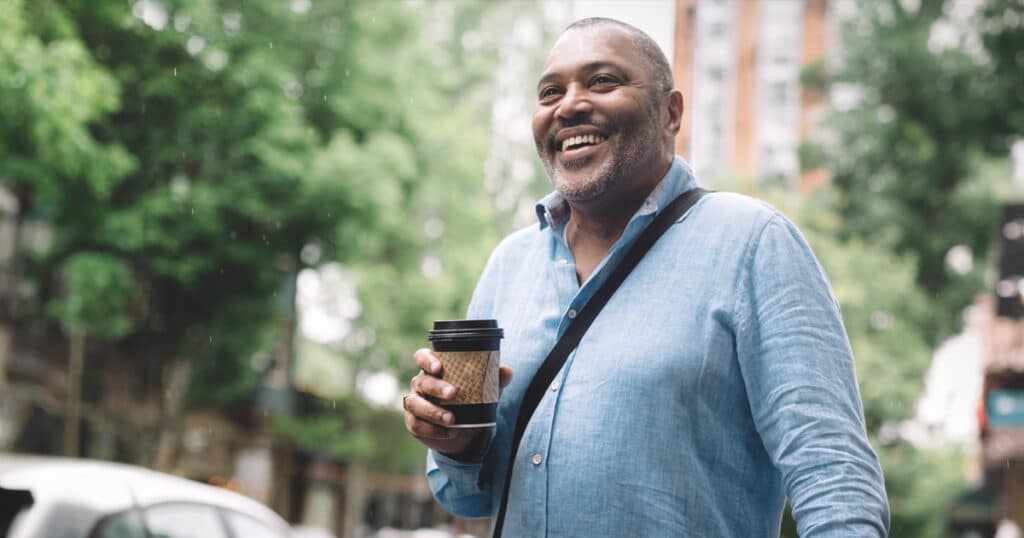 Man walking through a city with a coffee